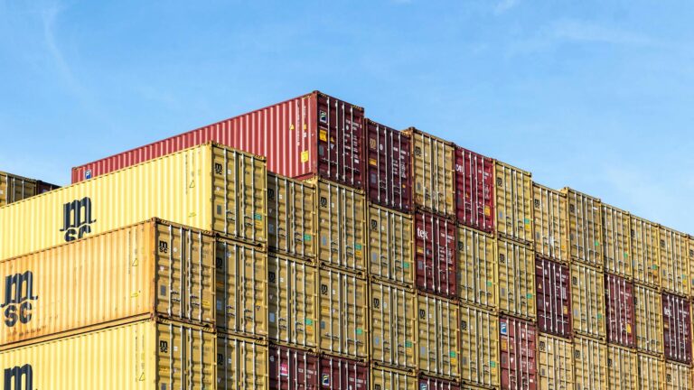 Containers empilhados no porto representando software de gestão de comércio exterior